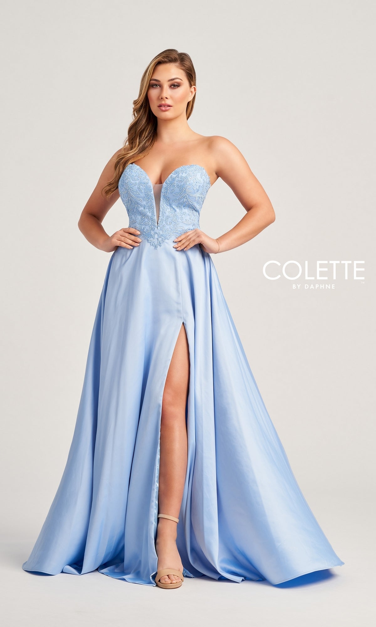 A woman models the Colette Strapless Long Designer Prom Dress CL5142, featuring a light blue hue, sweetheart neckline, lace bodice, and high leg slit, standing against a plain background.